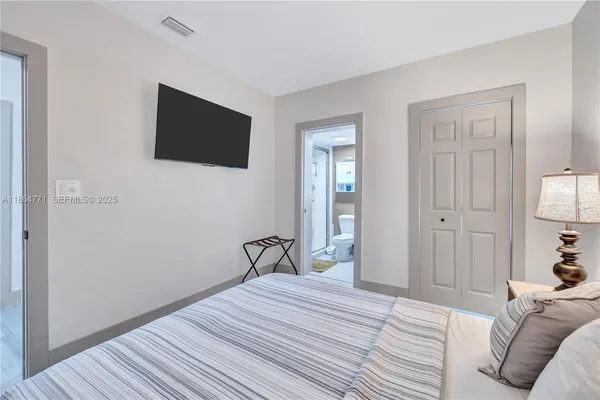 a bedroom with a bed and flat screen tv