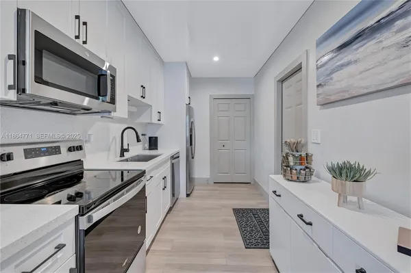 a kitchen with stainless steel appliances a sink microwave and cabinets