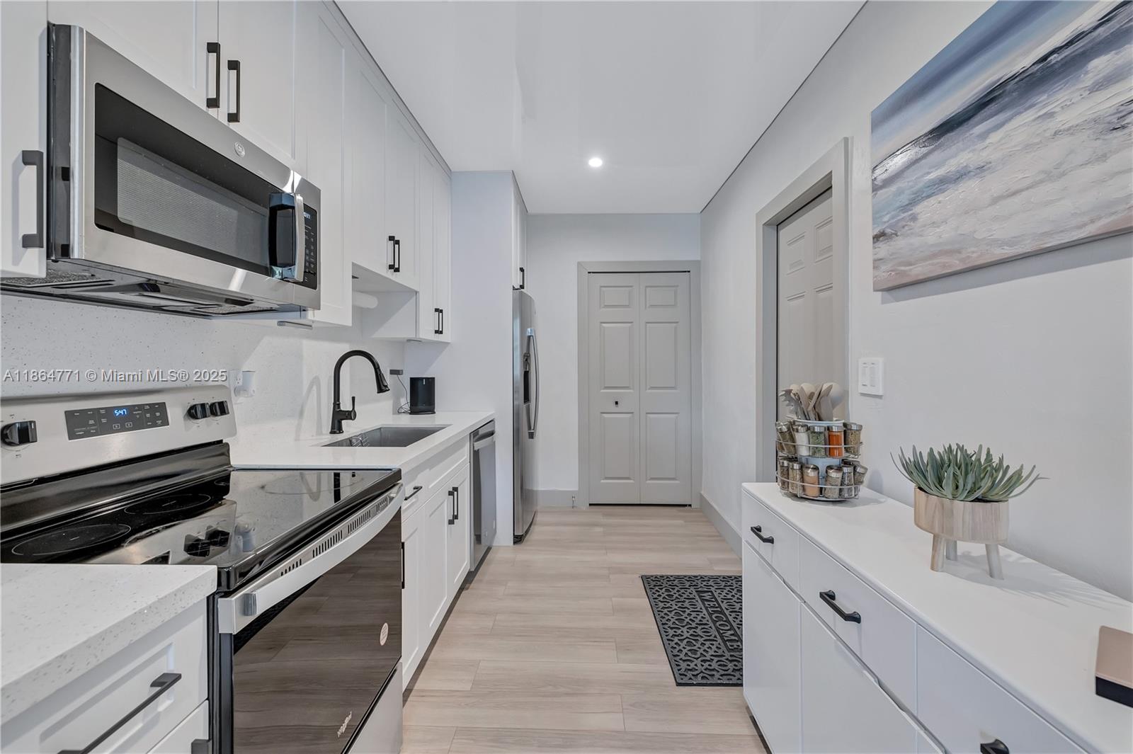 1390 Northeast 150th Street Miami, FL 33161 - Photo 6 of 31 a kitchen with stainless steel appliances a sink microwave and cabinets