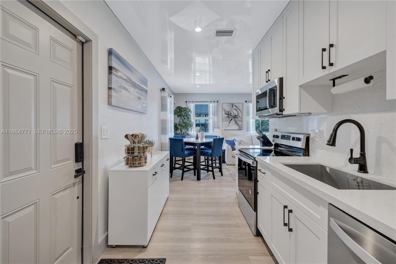 1390 Northeast 150th Street Miami, FL 33161 - Photo 8 of 32 a kitchen with white cabinets and sink