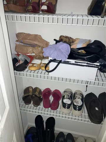a view of walk in closet with clothes and shoes