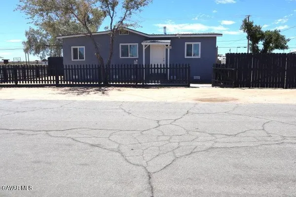 a view of a house with a fence in the yard