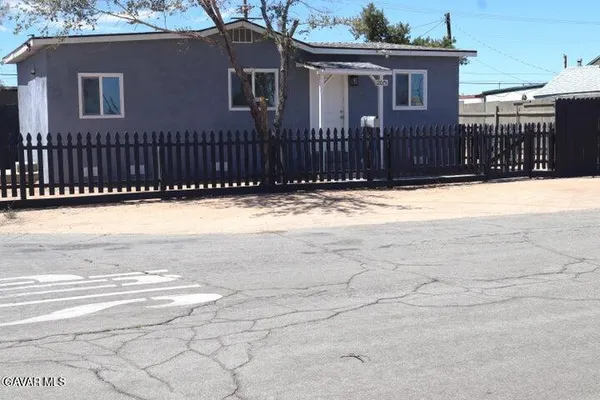 a view of a house with a wooden fence