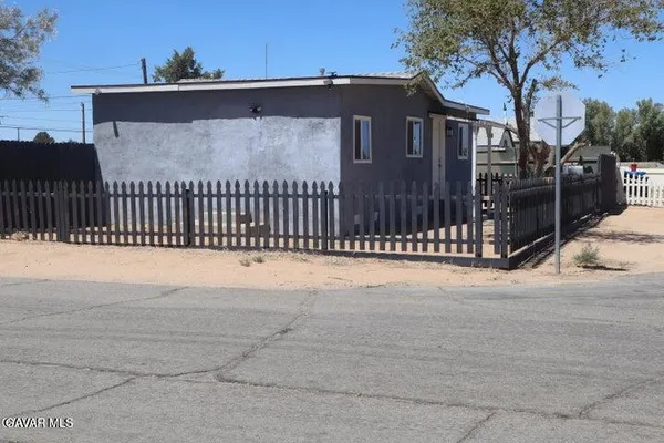 a view of a house with a wooden fence