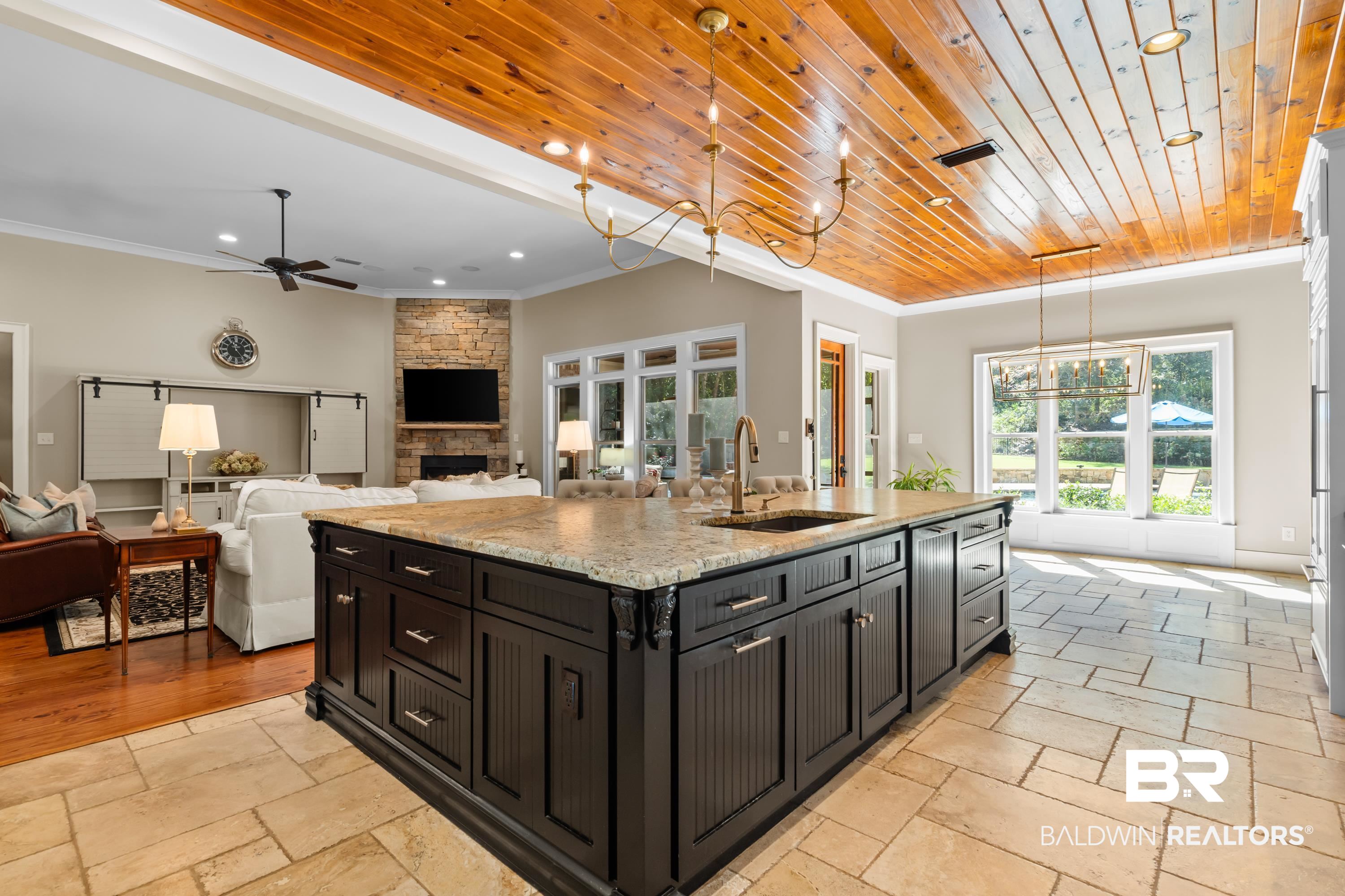 30057 Dolive Ridge Daphne, AL 36527 - Photo 15 of 55 Kitchen featuring hanging light fixtures, an island with sink, a fireplace, wooden ceiling, and ceiling fan
