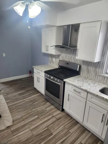 a kitchen with granite countertop white cabinets and white appliances