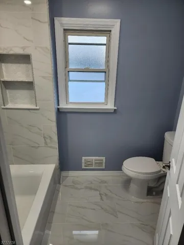 a bathroom with a toilet and a bathtub