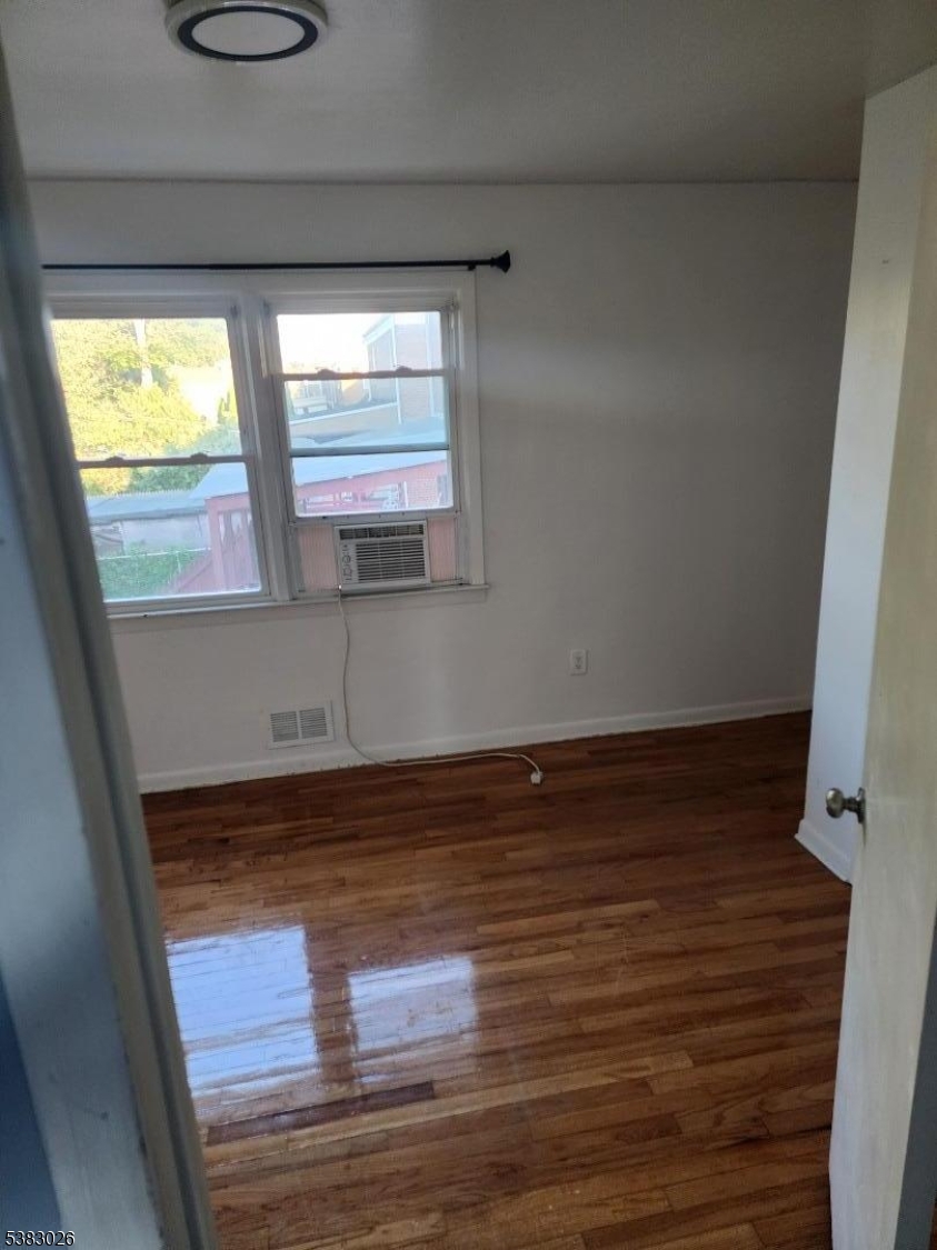 1371 Hamilton Street Elizabeth, NJ 07208 - Photo 8 of 9 a view of empty room with wooden floor and fan