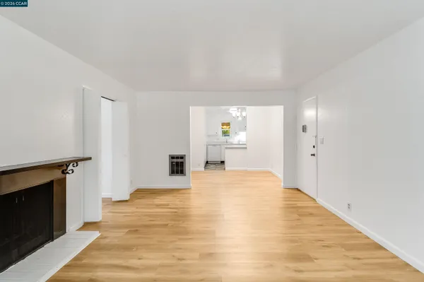 a big room with wooden floor and fireplace