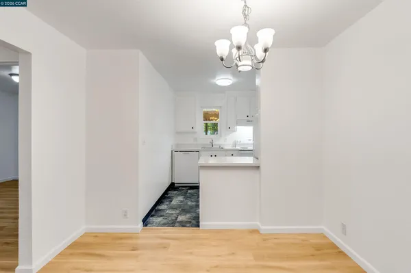 a view of a kitchen with a sink a chandelier and wooden floor