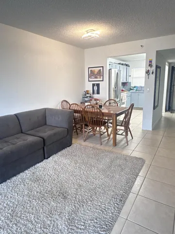 a living room with furniture a dining table and a rug