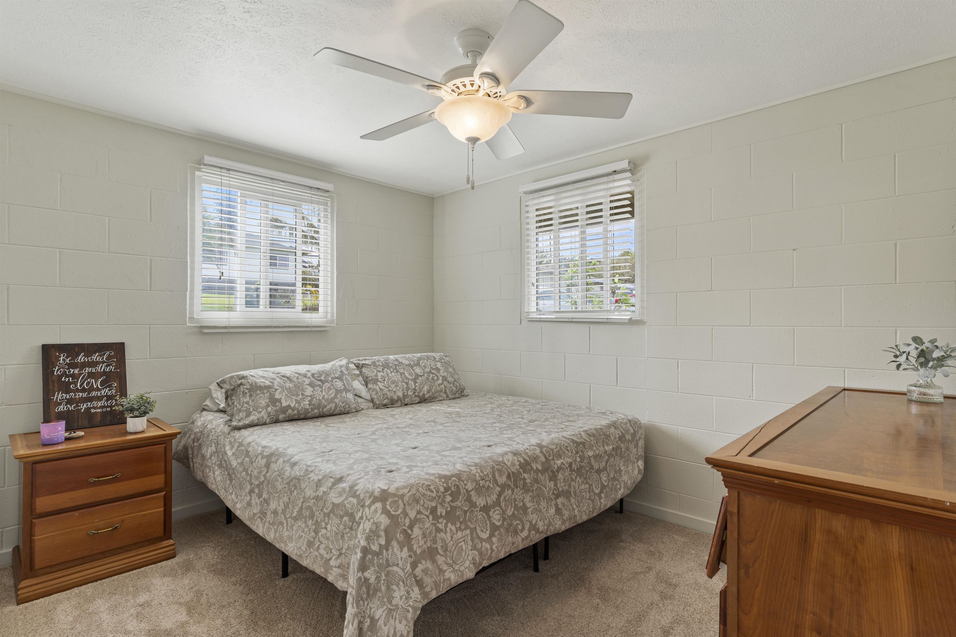 27 Maha Road, Unit 7 Makawao, HI 96768 - Photo 11 of 21 a bedroom with a bed and a chandelier