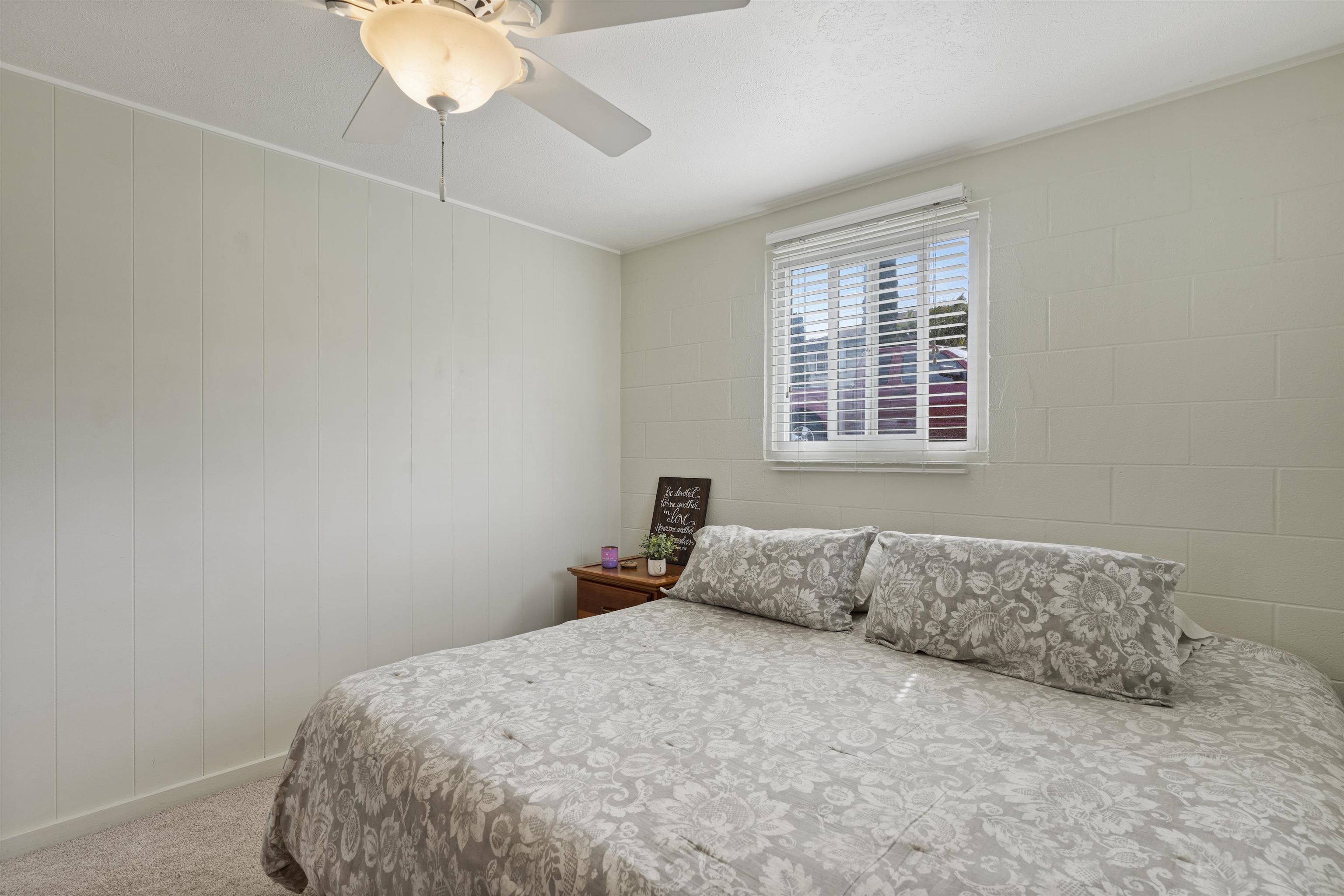 27 Maha Road, Unit 7 Makawao, HI 96768 - Photo 12 of 21 a bedroom with a bed and a chandelier