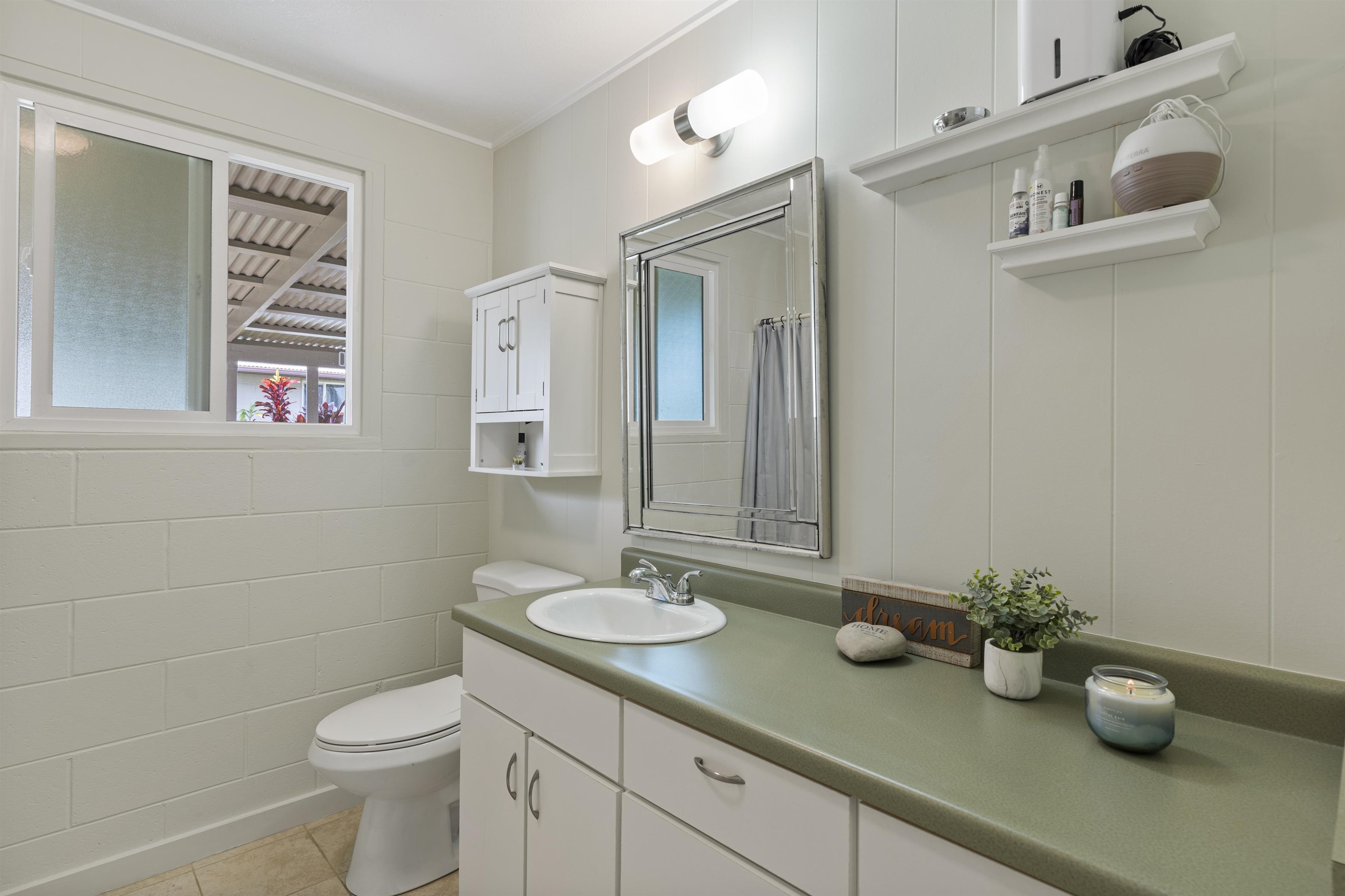 27 Maha Road, Unit 7 Makawao, HI 96768 - Photo 14 of 21 a bathroom with a sink a toilet and mirror