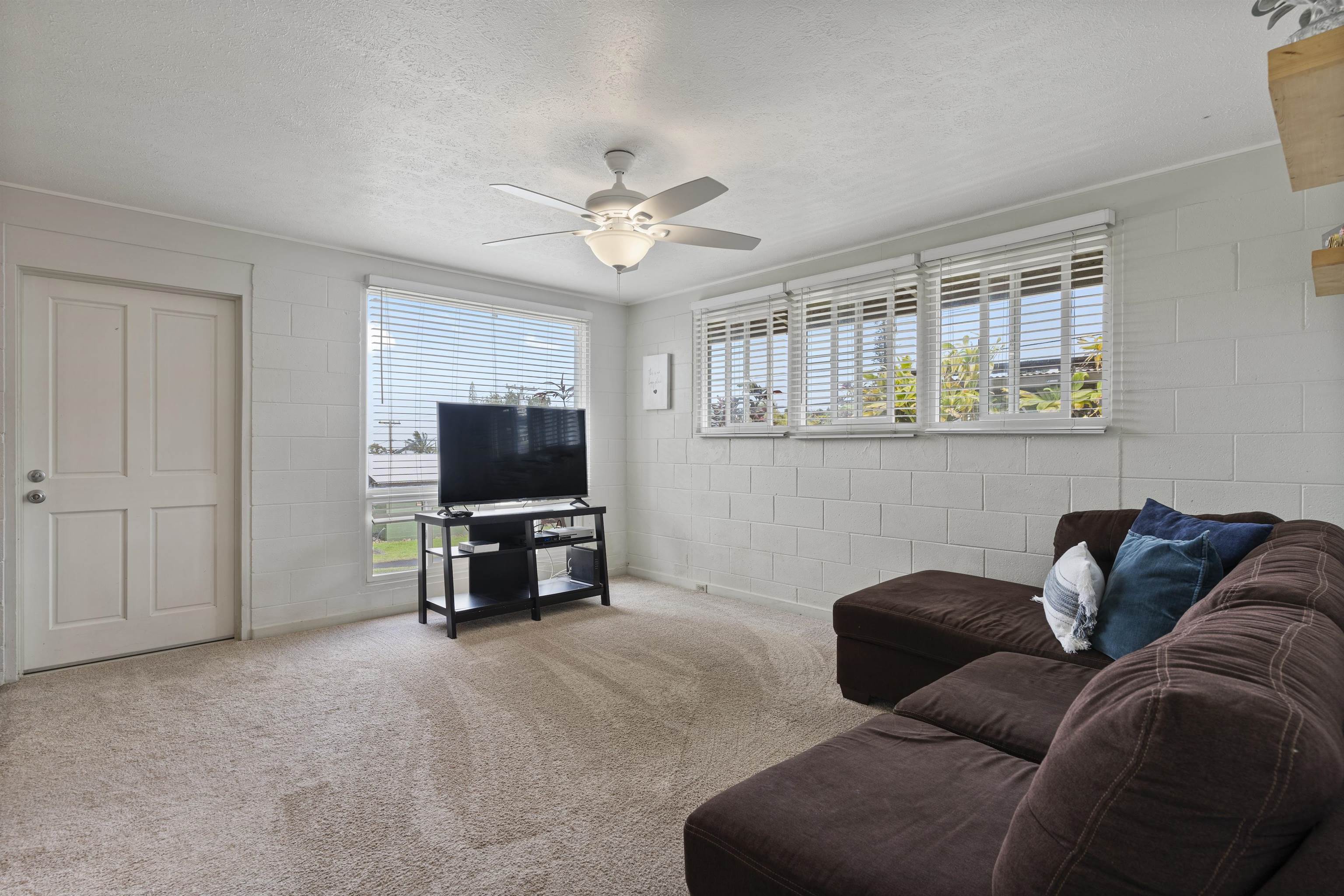 27 Maha Road, Unit 7 Makawao, HI 96768 - Photo 2 of 21 a living room with furniture and a flat screen tv