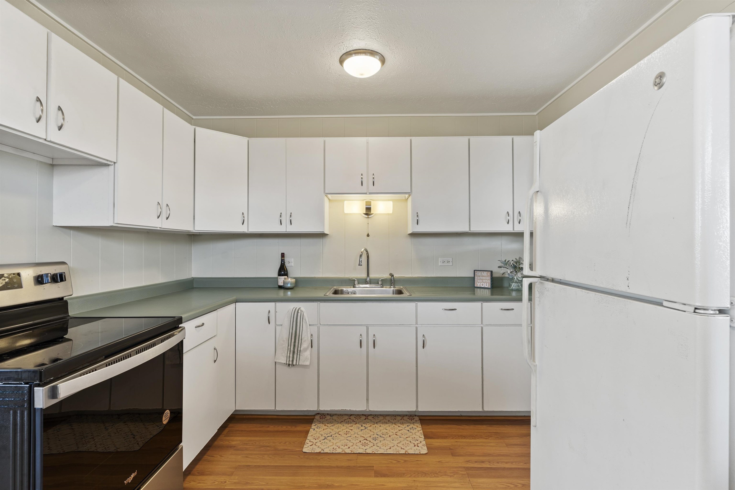 27 Maha Road, Unit 7 Makawao, HI 96768 - Photo 6 of 21 a kitchen with granite countertop a stove a sink and a refrigerator