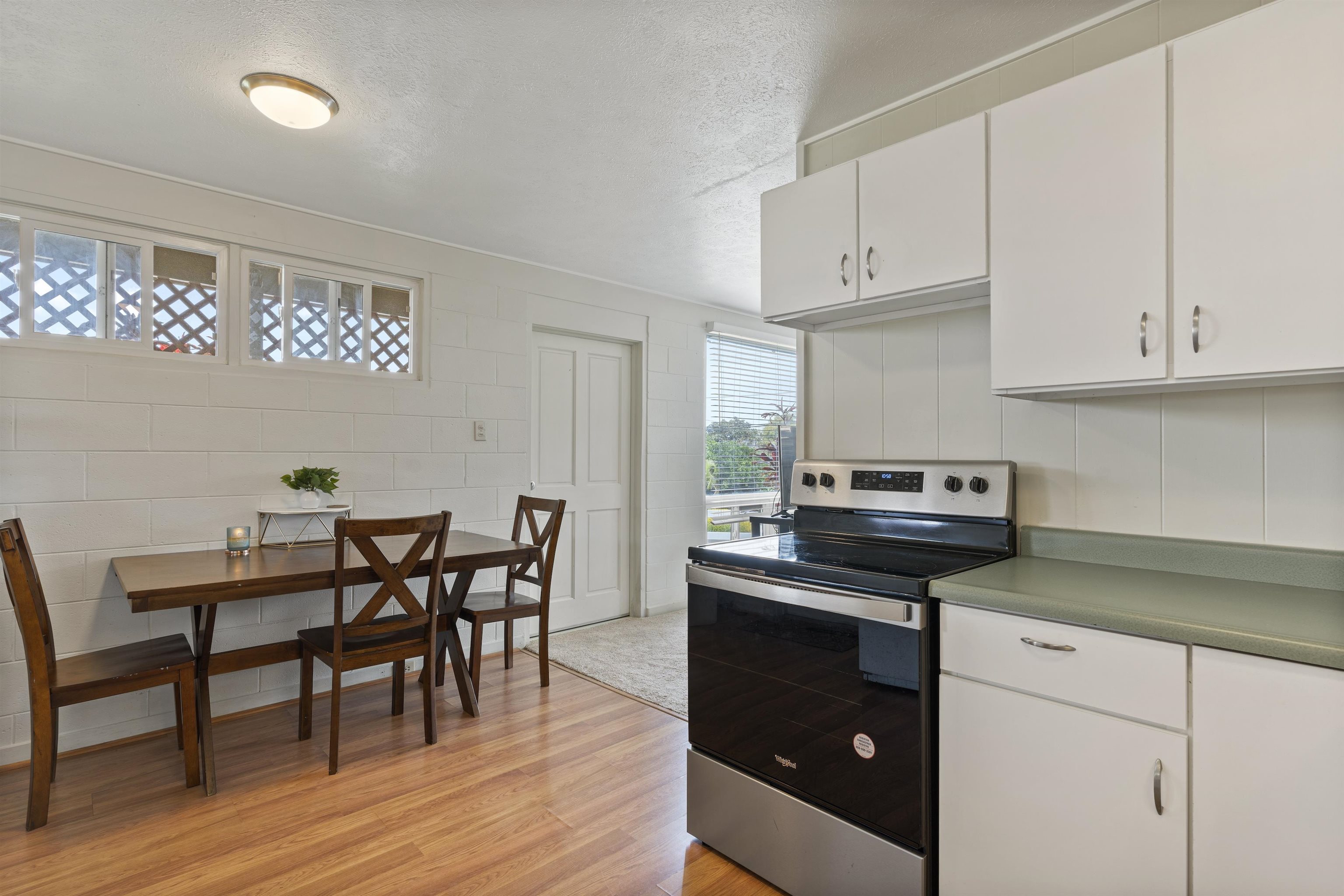 27 Maha Road, Unit 7 Makawao, HI 96768 - Photo 8 of 21 a kitchen with a stove a table and chairs in it