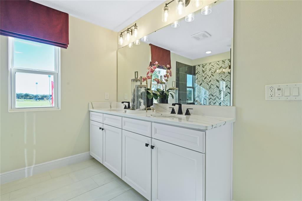 3633 Sublett Loop Tavares, FL 32778 - Photo 15 of 31 a bathroom with a double vanity sink mirror and next to a window