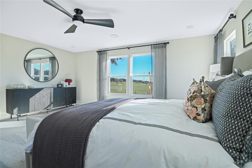 3633 Sublett Loop Tavares, FL 32778 - Photo 17 of 31 a bedroom with a large bed and a chandelier