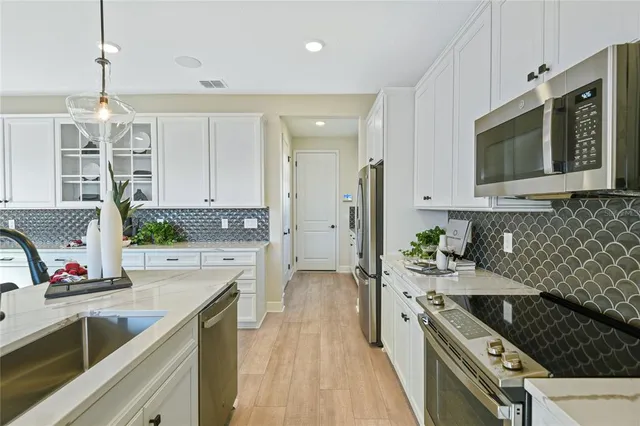 a kitchen with stainless steel appliances a stove sink microwave and cabinets