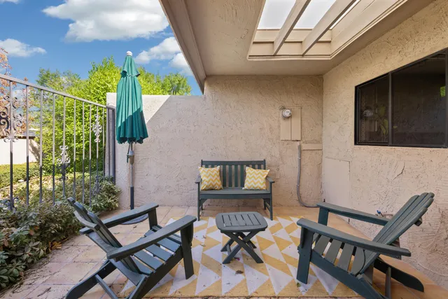a balcony with chairs and a potted plant