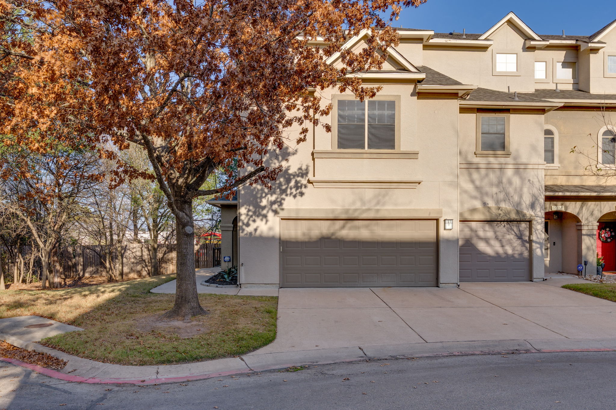 View of front facade featuring stucco siding, concrete driveway, a garage, a front yard, and roof with shingles
