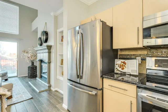 a kitchen with stainless steel appliances granite countertop a refrigerator stove and sink