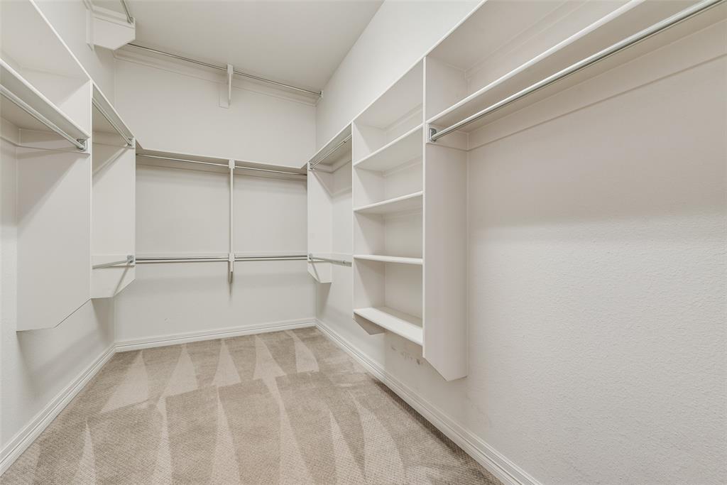 2021 Calisto Way Allen, TX 75013 - Photo 23 of 34 Walk-in closet featuring built-in shelving, multiple hanging rods, baseboards, and carpet flooring