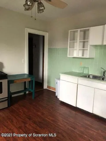 an empty room with wooden floor and cabinet