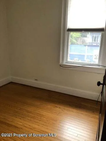 a view of a small space with wooden floor and a window