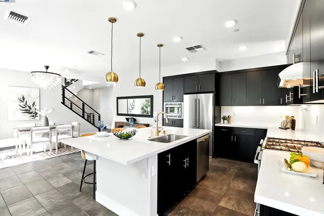 a kitchen with a sink a counter top space appliances and cabinets