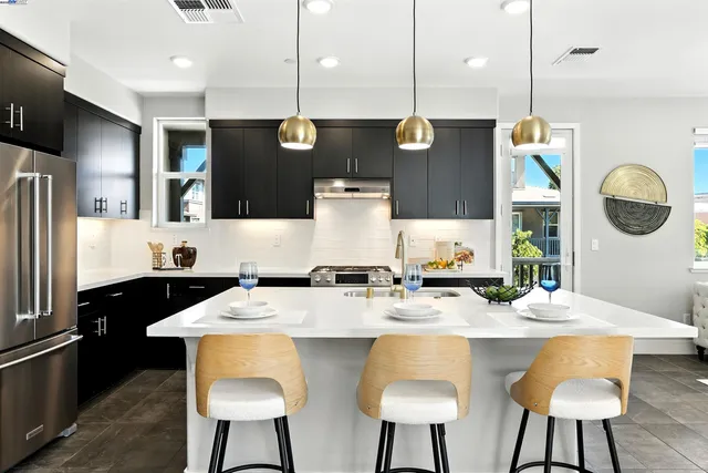 a large kitchen with a table chairs refrigerator and microwave