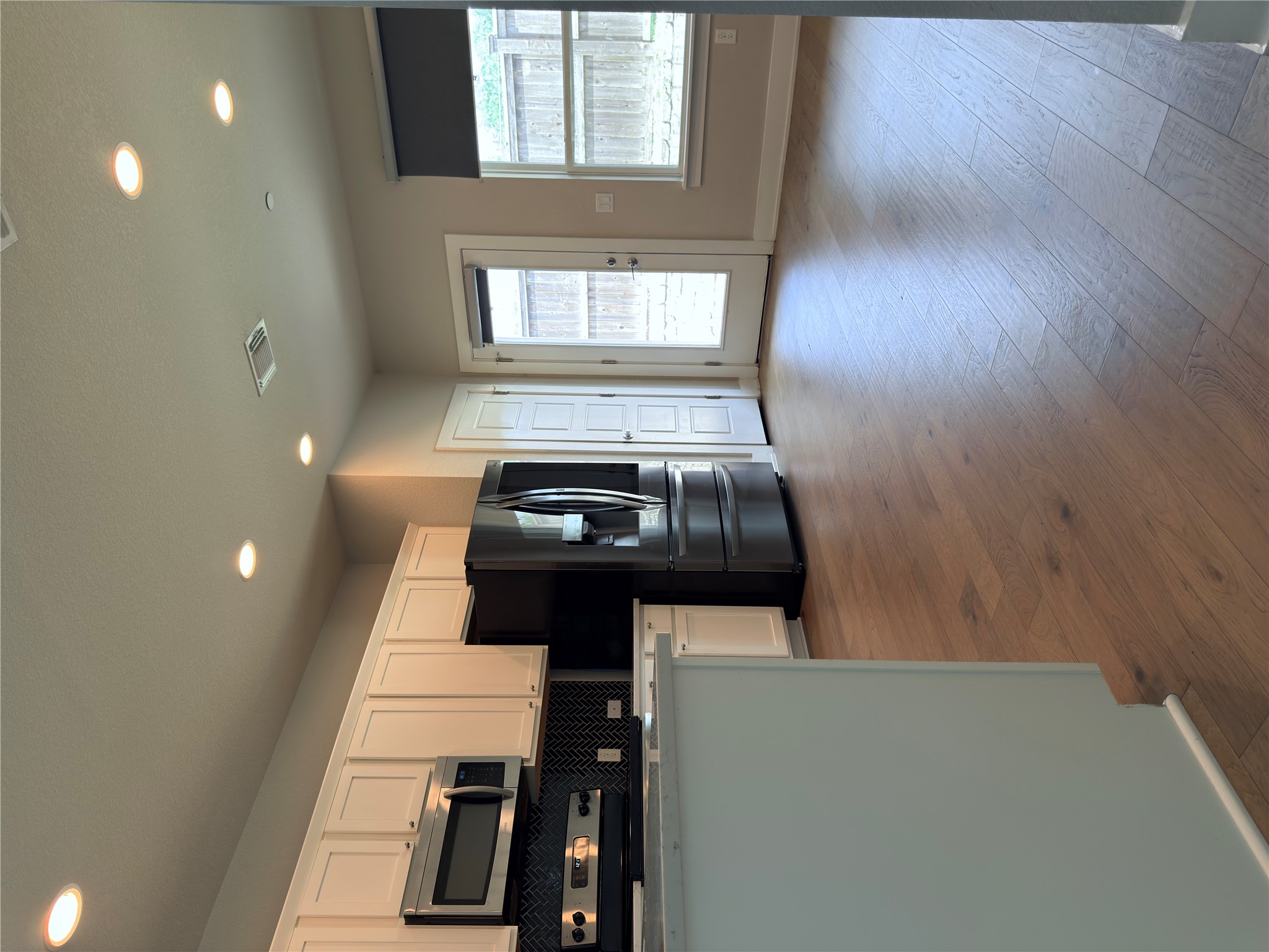 11216 Gadsen Lane Austin, TX 78754 - Photo 6 of 36 A pristine kitchen features sleek stainless steel appliances, abundant cabinetry, and durable hardwood flooring.