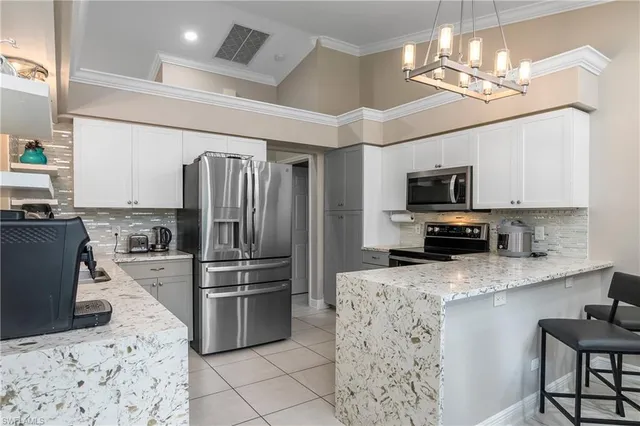 a kitchen with stainless steel appliances kitchen island granite countertop a refrigerator oven a sink dishwasher and a stove with wooden floor