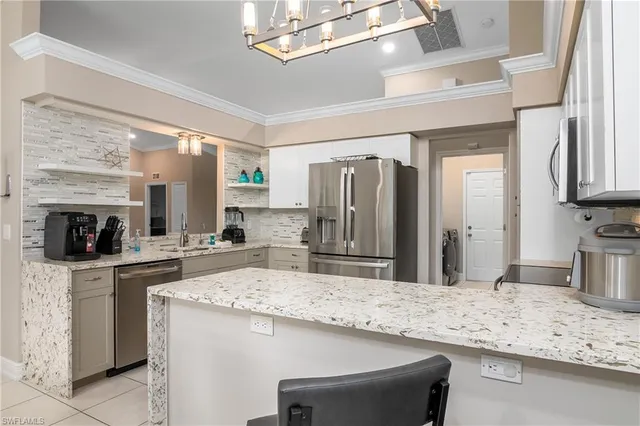 a kitchen with granite countertop a sink stove and refrigerator