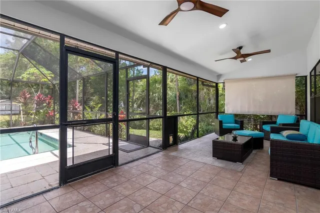 a living room with furniture and a floor to ceiling window