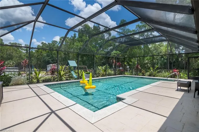 a view of a backyard with plants and table under an umbrella