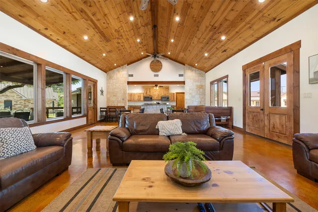 a living room with furniture a large window and a chandelier