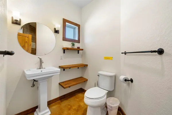 a bathroom with a sink toilet and mirror