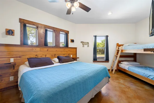 a bedroom with a bed and a dresser next to a window