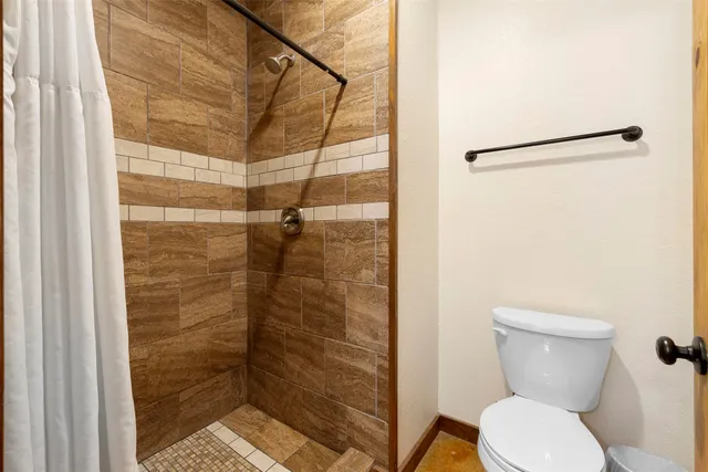 a bathroom with a toilet and a shower