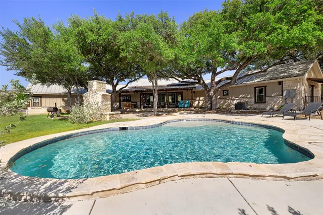 a swimming pool with outdoor seating and yard