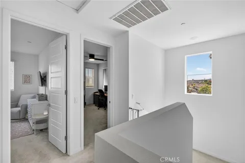 a view of a hallway with bathroom and mirror