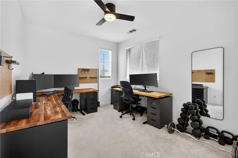 a view of a workspace with furniture and a window