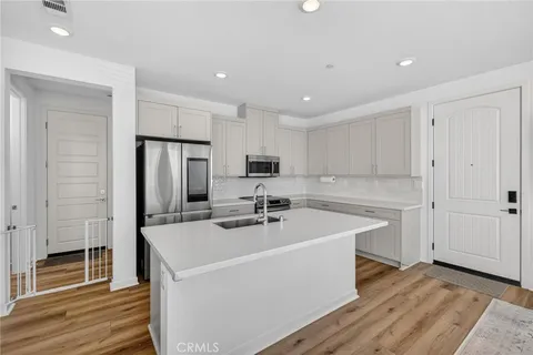 a kitchen with a sink a counter top space stainless steel appliances and cabinets