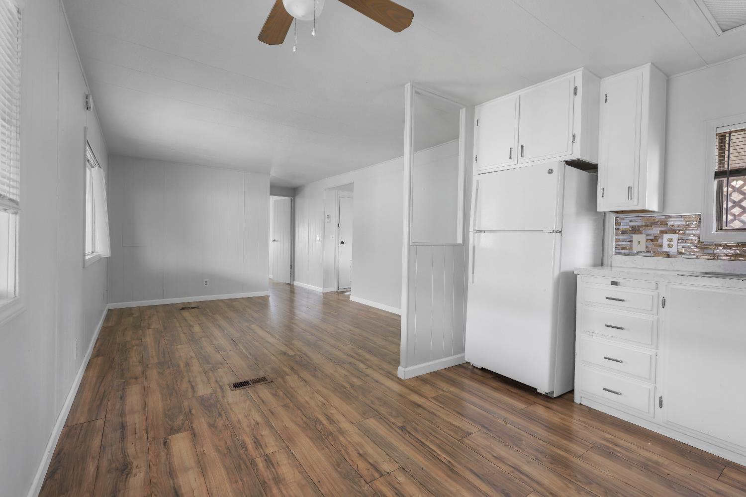 19142 North Jack Tone Road, Unit 34 Lockeford, CA 95237 - Photo 14 of 21 a kitchen with wooden floors and white appliances