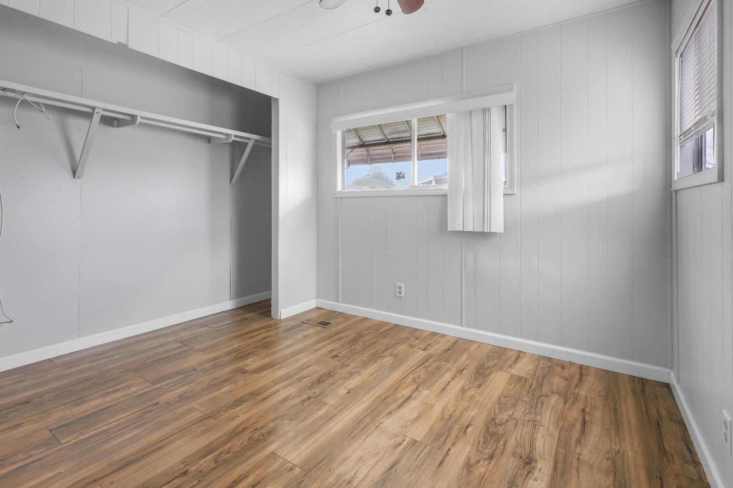 19142 North Jack Tone Road, Unit 34 Lockeford, CA 95237 - Photo 18 of 21 a view of an empty room with wooden floor and a window