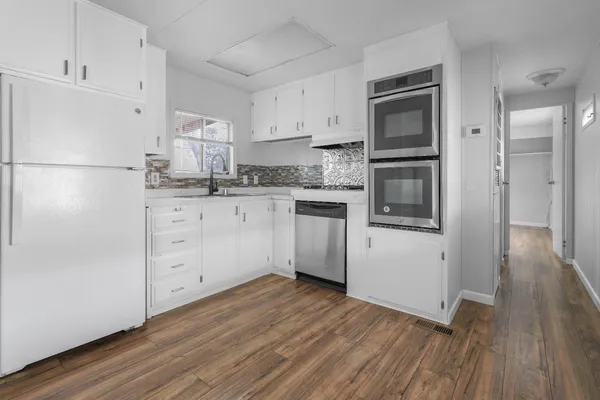 a kitchen with granite countertop white cabinets and white appliances