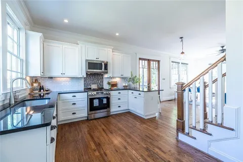 a kitchen with wooden floor and chairs