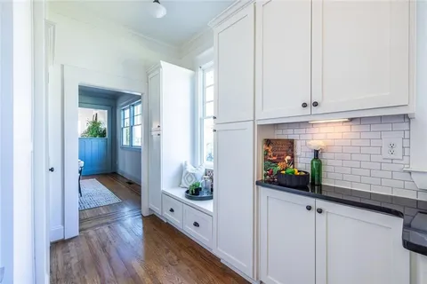 a view of a hallway with wooden floor and windows